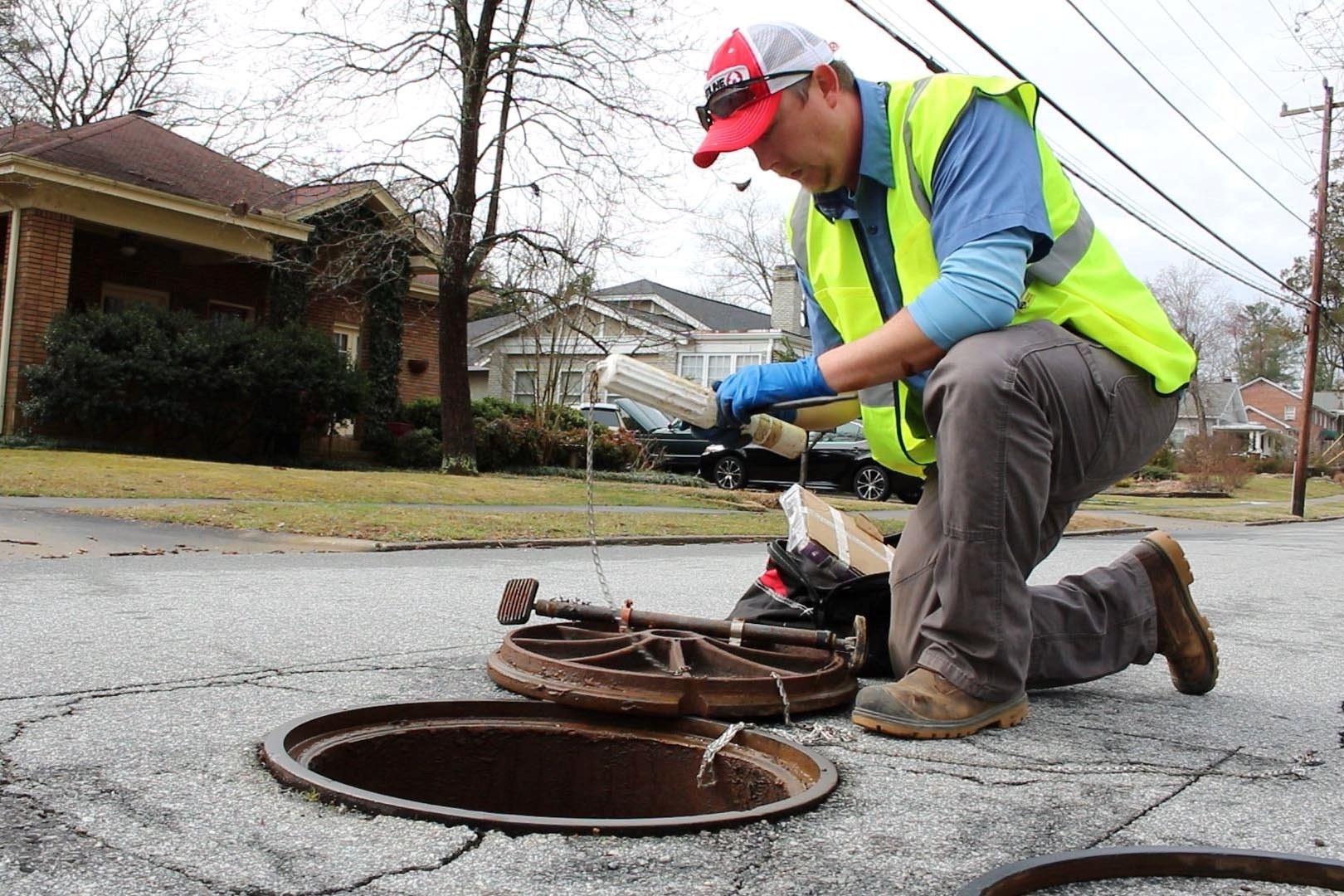 City staff install sewer flow tracking device